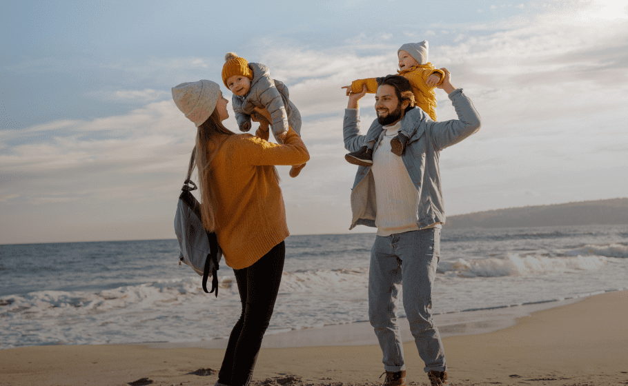 Family enjoying time on the beach with young children
